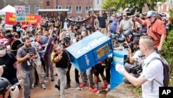ARSIP – Pengunjukrasa nasionalis kulit putih, kanan, bentrok dengan pengunjuk rasa tandingan saat ia melemparkan kotak surat kabar di jalan masuk ke Lee Park di Charlottesville, Va (foto: AP Photo/Steve Helber, Arsip)