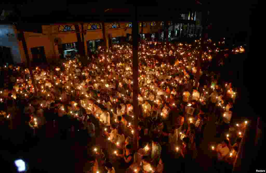 Participants hold candles during a mass prayer to call for justice in the trials of dissident blogger Nguyen Huu Vinh and land protection activist Can Thi Theu at Thai Ha church in Hanoi, Vietnam, Sept. 18, 2016.