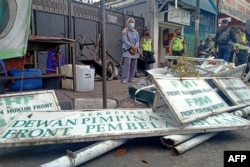Polisi menurunkan papan nama di markas organisasi FPI (Front Pembela Islam) di Jakarta pada 30 Desember 2020. (Foto: AFP)