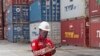 Seorang pekerja sedang mencatat data dekat tumpukan peti kemas di pelabuhan Tanjung Priok, Jakarta, 8 Oktober 2021. (Foto: Tatan Syuflana/AP Photo)