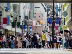 Para pejalan kaki mengenakan masker saat berjalan di pusat kota Tokyo, Jepang, di tengah pandemi COVID-19, di 14 Mei 2021. (REUTERS / Naoki Ogura)