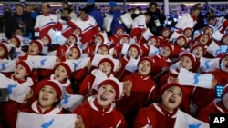 Članovi severnokorejske delegacije sa zastavom dve Koreje na ceremoniji otvaranja ZOI 9. februara 2018.
