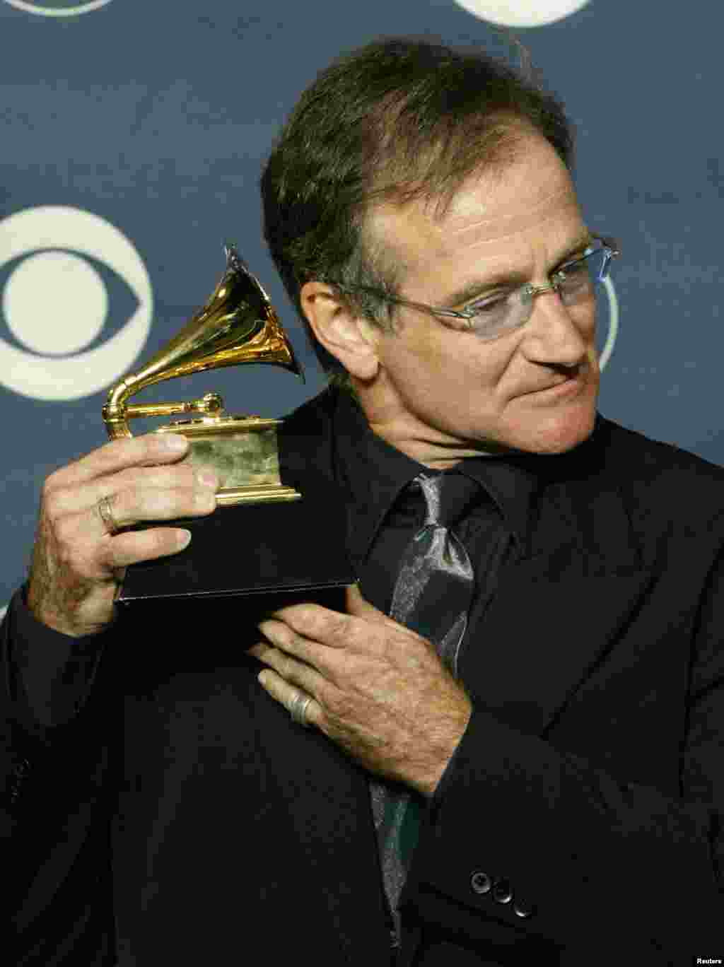 Komedian Robin Williams memegang Grammy Award ketika berpose bagi para fotografer di acara tahunan Grammy Awards ke-45 di Madison Square Garden, at New York, 23 Februari 2003. Williams memenangkan Grammy kategori "Best Spoken Comedy Album" untuk "Robin Williams Live 2002."