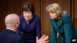 Homeland Security Secretary Alejandro Mayorkas, left, talks with Sen. Susan Collins, R-Maine, center, and Sen. Lisa Murkowski, R-Alaska, right, during a break of the Senate Appropriations committee hearing to examine domestic extremism, Dec. 5, 2021.