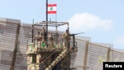 FILE - Lebanese army members stand on an observation tower in Naqoura, near the Lebanese-Israeli border, southern Lebanon, Aug. 8, 2023. The Israeli military reportedly has withdrawn from the town following a ceasefire agreement reached in November 2024. 