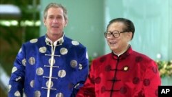 U.S. President George W. Bush and Chinese President Jiang Zemin wear traditional style silk jackets as they walk to an informal meeting at the Asia Pacific Economic Cooperation (APEC) leader's summit in Shanghai, China, on Sunday, Oct. 21, 2001. (AP Photo/Vincent Yu)