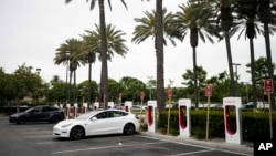 FILE - Kendaraan listrik Tesla di stasiun pengisian daya di Anaheim, California, 9 Juni 2023. Penjualan kendaraan listrik diperkirakan mencapai rekor sembilan persen dari seluruh kendaraan penumpang di AS tahun ini, menurut Kebijakan Publik Atlas. (AP/Jae C. Hong)