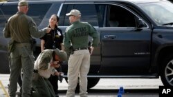 Law enforcement officials process a scene involved in Saturday's shooting, Sunday, Sept. 1, 2019, in Odessa, Texas. 