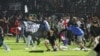 Suporter Arema FC memasuki lapangan usai tim yang mereka dukung kalah dari Persebaya usai pertandingan sepak bola liga BRI Liga 1 di Stadion Kanjuruhan, Malang, Jawa Timur, 2 Oktober 2022. (Foto: Antara/Ari Bowo Sucipto via REUTERS)