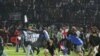 Suporter Arema FC memasuki lapangan setelah tim yang mereka dukung kalah dari Persebaya usai pertandingan liga BRI Liga 1 di Stadion Kanjuruhan, Malang, Provinsi Jawa Timur, 2 Oktober 2022. (Antara Foto/Ari Bowo Sucipto/via REUTERS)