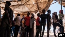 FILE - Eritrean refugees queue during a distribution of items organized the UNHCR at Mai Aini Refugee camp, in Ethiopia, Jan. 30, 2021.