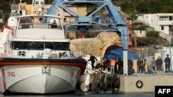 Një grup imigrantësh ngjiten në anijen e rojës italiane detare në portin e Shëngjinit, në Shqipëri, më 19 tetor, 2024/Arkiv/AFP