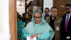 Mantan Perdana Menteri Bangladesh Sheikh Hasina tampak memeriksa jam tangannya saat menunggu giliran untuk menggunakan hak pilihnya di salah satu tempat pemungutan suara di Dhaka, Bangladesh, pada 7 Januari 2024. (Foto: AP/Altaf Qadri)