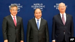 Vietnamese Prime Minister Nguyen Xuan Phuc, center, Chinese Vice Premier Hu Chunhua, left, and Klaus Schwab, executive chair of the World Economic Forum, pose prior to the World Economic Forum on ASEAN Wednesday, Sept. 12, 2018 .