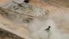 A Syrian APC moves raising dust in Harasta, northeast of Damascus, Syria, Oct. 22, 2015. 