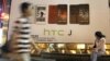 Man walks past an advertising board of Taiwan's smartphone maker HTC Corp. in Taipei, Taiwan, Oct. 25, 2012.