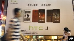 Man walks past an advertising board of Taiwan's smartphone maker HTC Corp. in Taipei, Taiwan, October 25, 2012.