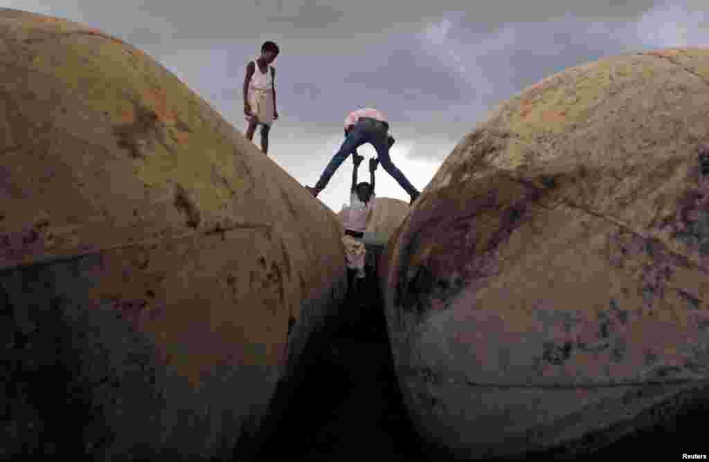Children play on pontoons as clouds gather over the banks of the river Ganges in Allahabad, India.