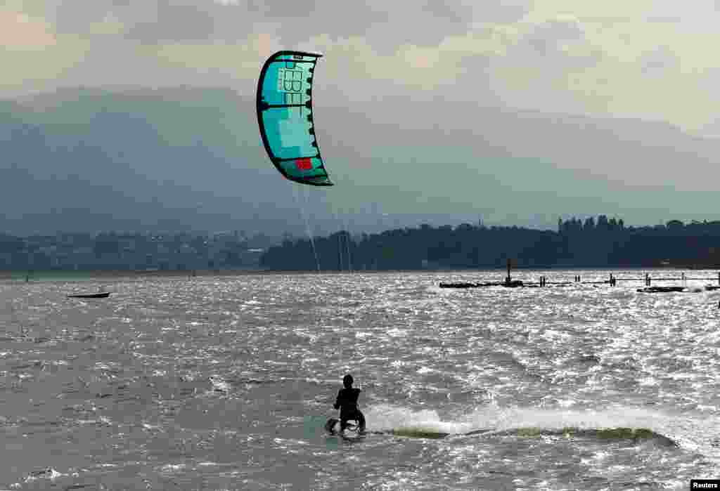 A man kite surfs on a strong northerly windy day on Lake Leman in Geneva, Switzerland.