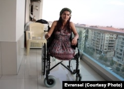 FILE - Lisa Calan on her wheelchair while being interviewed by Turkish reporters at her home five months after the Diyarbakir bombing that cost her two legs, Diyarbakir, Turkey, Oct. 2015.