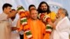 FILE - Supporters of Yogi Adityanath (C), Chief Minister of India's most populous state of Uttar Pradesh, present him with a garland on the occasion of the birthday celebration of Nritya Gopal Das, a famous Hindu priest, in Ayodhya, India, May 31, 2017. 