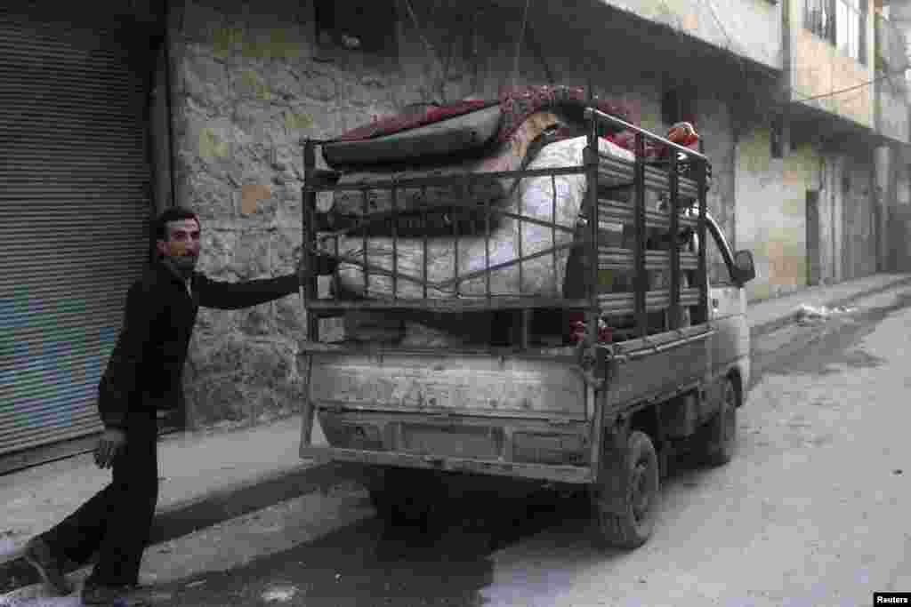 A resident packs his belongings after what activists said was an air strike by forces loyal to Syria's President Bashar Al-Assad in Al-Maysar, Aleppo, Jan. 19, 2014.