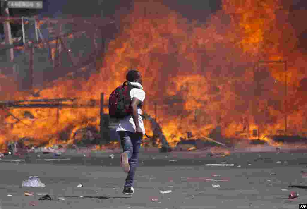 Zimbabwe's opposition supporters set up a burning barricade as they clash with police during a protest for electoral reforms in Harare.