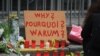 A placard outside one of the entrances to the Maelbeek metro station asks ‘why’ while other writing expresses calls for both peace and anger in Brussels, Belgium, March 24, 2016. (H. Murdock/VOA)