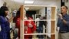 U.S. President Barack Obama and first lady Michelle Obama paint shelves at Burrville Elementary School as they participate in a day of service, hoping to encourage Americans to follow suit with volunteering projects nationwide, Washington, January 19, 2013. 