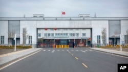 FILE - Police officers stand at the outer entrance of the Urumqi No. 3 Detention Center in Dabancheng in western China's Xinjiang Uyghur Autonomous Region, April 23, 2021.