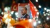 People wave flags and hold a portrait of Turkish President Recep Tayyip Erdogan as they celebrate the ruling AK Party's election win, in Ankara, Turkey Nov. 2, 2015.