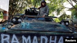 A Philippines army soldier stands on a tank inside the city hall compound in Marawi as government forces continue their assault against insurgents from the Maute group, June 25, 2017. 