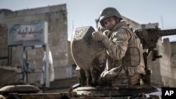 Arhiva - Vojnik podiže prst dok oklopna vozila turske vojske ulaze u sirijski grad Ajn al Arab, 22. februara 2015. (AP Photo/Mursel Coban, Depo Photos, File)