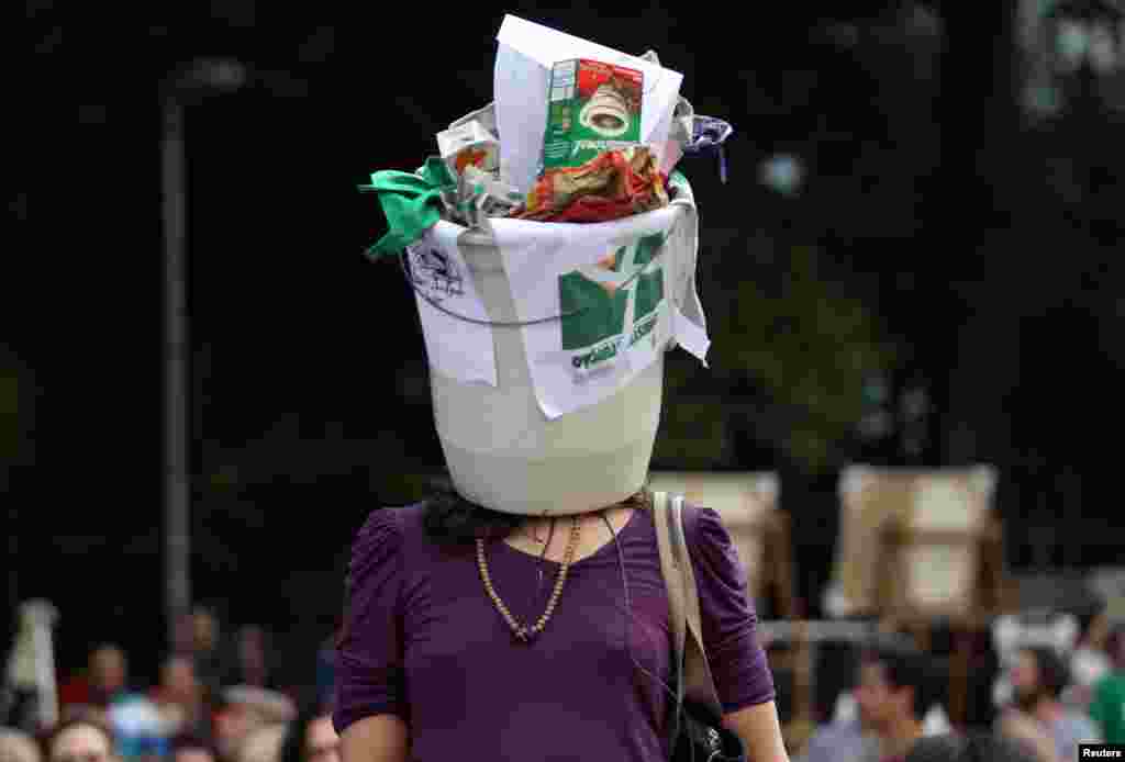 A demonstrator wears a garbage bin on her head during a protest against President Michel Temer in Sao Paulo, Brazil, Sept. 11, 2016.