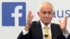 FILE - Australian Prime Minister Malcolm Turnbull raises his hands as he speaks during a leaders debate hosted by Facebook Australia and News.com.au in Sydney, June 17, 2016. The Australian government on July 14, 2017, proposed a new cybersecurity law to force global technology companies such as Facebook and Google to help police by unscrambling encrypted messages sent by suspected extremists and other criminals. 