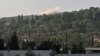 Smoke rises in the horizon as Hayat Tahrir al-Sham (HTS) jihadist group's advance toward Syrian opposition-held areas in the northern Aleppo province on Oct. 17, 2022.