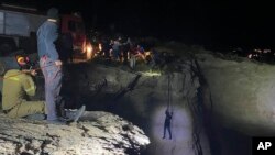 Pihak berwenang dan penduduk setempat menarik seorang migran ke tempat aman setelah perahu layar yang membawa hingga 100 migran tenggelam di dekat Pulau Kythira, selatan Athena, Yunani, 6 Oktober 2022. (Foto: via AP)
