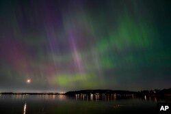 FILE - The northern lights, or aurora borealis, are visible over Lake Washington, in Renton, Wash., May 10, 2024.