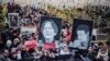 Russian opposition protestors march in central Moscow, Jan. 19, 2020, carrying portraits of lawyer Stanislav Markelov and journalist Anastasia Baburova.