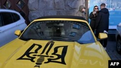 Національна стратегія надходжень має забезпечити потреби бюджету в час невизначеності щодо великих пакетів донорів, кажуть в МВФ. Фото для ілюстрації: машина в Києві оздобена гербом України, грудень 2023 року.