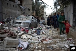 Warga Palestina menyaksikan dampak serangan udara Israel di Rafah, Jalur Gaza, Jumat, 9 Februari 2024. (Foto: AP)