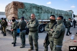 Tentara Israel berdiri di dekat salah satu truk Mesir yang membawa pasokan bantuan kemanusiaan ke Jalur Gaza, di sisi Israel di perbatasan Kerem Shalom yang melintasi wilayah Palestina pada 6 Februari 2024.