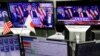FILE - An employee of a foreign exchange trading company looks at monitors showing U.S. President elect Donald Trump speaking on TV news in Tokyo, Japan, Nov. 9, 2016. 