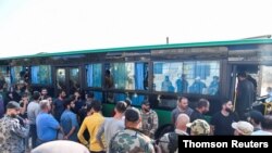 Buses carrying rebels and their families are seen in Deraa, the city that was the birthplace of peaceful protests against autocratic Assad family rule that broke out a decade ago.