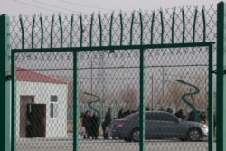 FILE - Residents line up inside the Artux City training center in western China's Xinjiang region, Dec. 3, 2018.