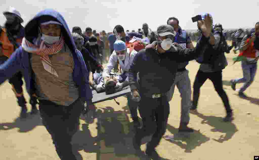 'Yan agajin gaggawar Falasdinu a lokacin da suke dauke da wani yaro da ya ji mummunan rauni lokacin da ake zanga zanga a iyakar Gaza da Isra'ila. 14 ga watan Mayu 2018