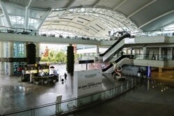 Seorang wisatawan berjalan menyusuri terminal kedatangan internasional yang sepi di bandara Gusti Ngurah Rai, Bali, di tengah pandemi COVID-19, 1 April 2020. (Foto: REUTERS/Johannes P. Christo)
