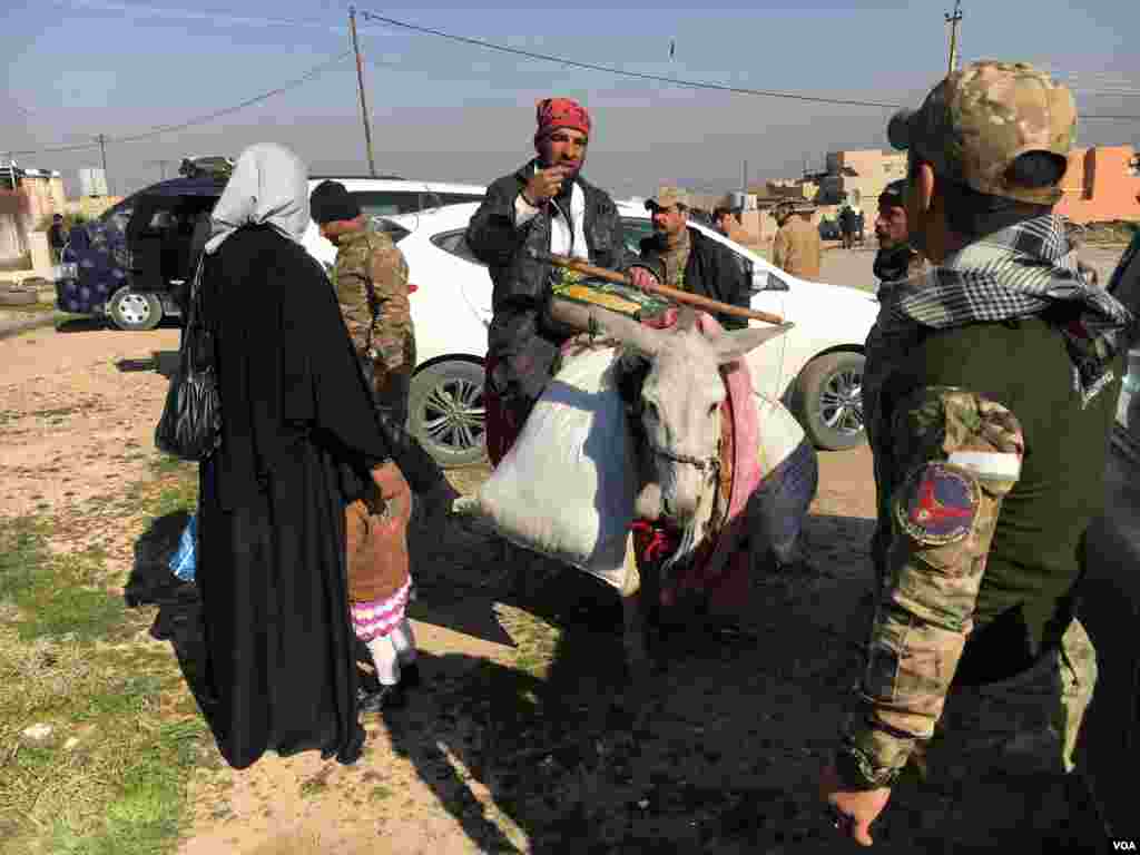 Wasu fararen hula sun kwace kayukansu kuma sun bar garin Mosul yayinda dakarun Iraqi ke korar yan kungiyar ISIS daga filin jirgin sama, ranar 23 ga watan Fabrairu , 2017 (K. Omar/VOA)
