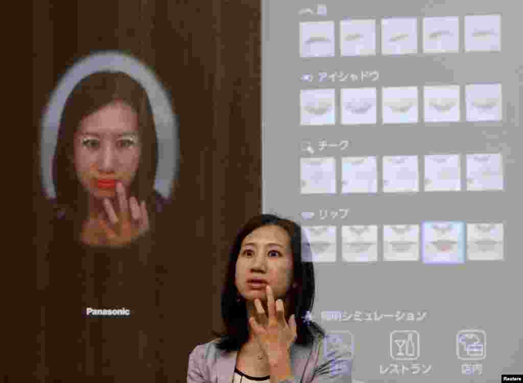 A woman is reflected in Panasonic Corp's interactive mirror, which is able to apply virtual makeup and detect skin condition, during a demonstration at CEATEC (Combined Exhibition of Advanced Technologies) JAPAN 2015 in Makuhari, Japan.