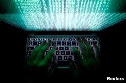 FILE - A man types on a computer keyboard in this photo illustration, Feb. 28, 2013. "Adversaries use the internet as an echo chamber in which information, ideas or beliefs get amplified or reinforced through repetition," says the U.S. top intelligence official.